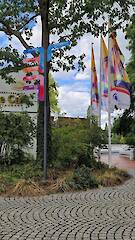 Individueller Fahnenwegweiser (Standrohr, Säule mit 12 Nuten, Nutprofil als Klemmhalter mit individuellen Aluminiumverbund-Fahnen) im Flora-Westfalica-Park in Rheda-Wiedenbrück